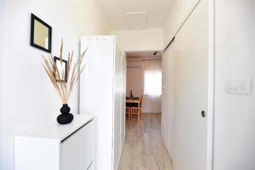 a hallway with white walls and a vase on a table at Ferienwohnung für 2 Personen 1 Kind ca 40 qm in Ljubač bei Zadar, Dalmatien Norddalmatien in Ljubač