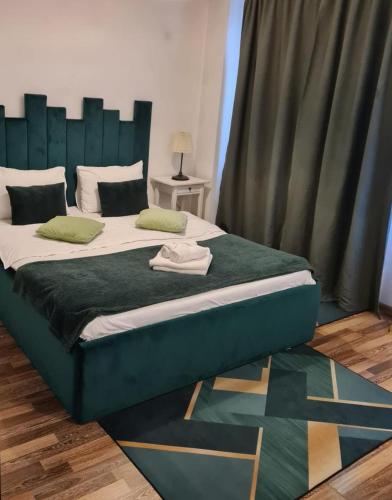 a large bed with a green headboard in a room at Apartament Fundeni in Bucharest