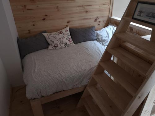 Ce petit lit se trouve dans une chambre dotée d'un mur en bois. dans l'établissement La Cordonnerie, à Messeix
