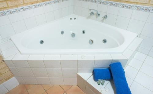 Kalbarri Palm Resort في كالباري: حوض استحمام كبير أبيض في الحمام
