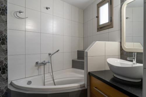 ein Bad mit einer Badewanne, einem Waschbecken und einer Dusche in der Unterkunft Nefele Maisonette near Heraklion centre in Iraklio