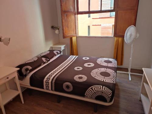 Cama en habitación con ventana en Apartamentos la Concepción grupos, en La Laguna