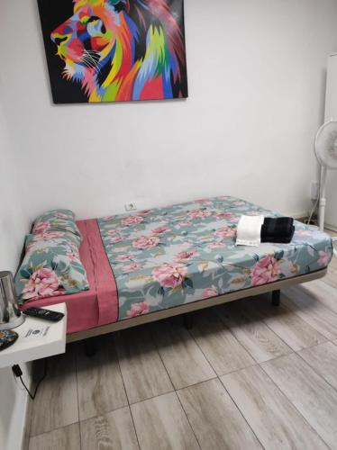 1 cama en una habitación con un cuadro en la pared en Apartamentos la Concepción grupos, en La Laguna