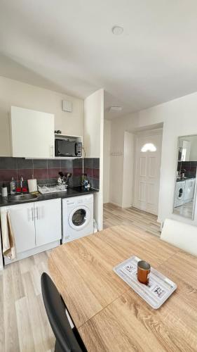 une cuisine avec une table et une cuisine avec une cuisinière dans l'établissement Charmant T1 entre ville et lac avec balcon, à Aix-les-Bains