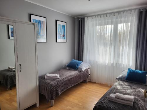 a small bedroom with two beds and a mirror at Apartament INA in Puck