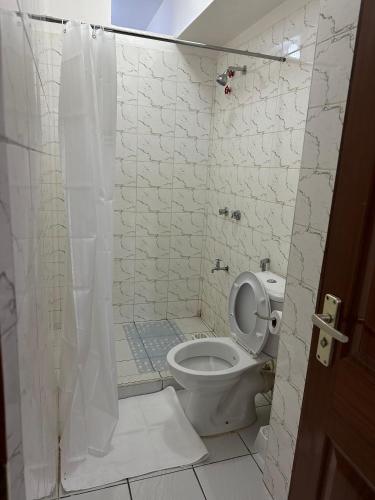 a bathroom with a toilet and a shower at Kilimanjaro Splendor - 3BR Condo in Kisumu