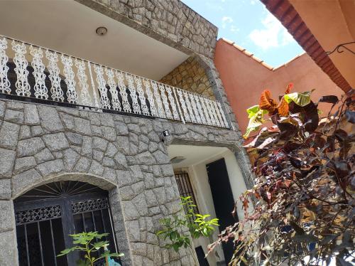 a stone building with a balcony with a gate at Mi Casa Wi-Fi e Garagem Grátis Próx Praia do Recreio in Rio de Janeiro