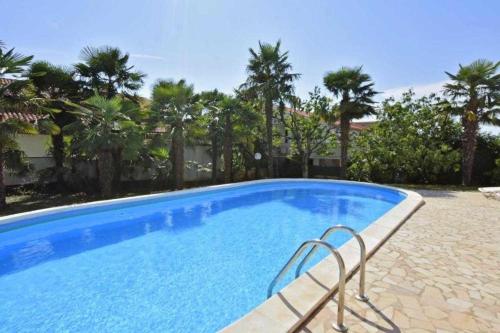 une grande piscine bleue avec un banc dans une cour dans l'établissement Ferienwohnung für 2 Personen ca 18 qm in Poreč, Istrien Istrische Riviera, à Poreč