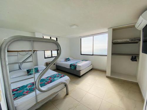 um quarto com 2 beliches e uma janela em Apartamento Iroka 10D frente al mar em Santa Marta