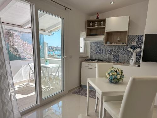una piccola cucina con tavolo e finestra di La Perla Azzurra a Gaeta