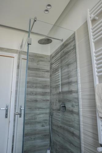 a shower in a bathroom with a wooden wall at Attico vista mare in Gaeta