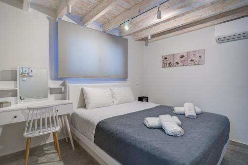 a bedroom with a bed with a desk and a mirror at Molos Beachfront Apartments in Diakopto in Diakopto