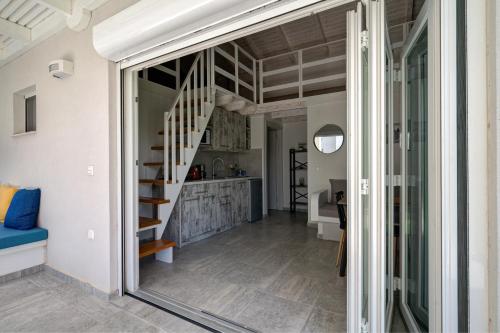 a view from the living room into the kitchen and stairwell of a house at Molos Beachfront Apartments in Diakopto in Diakopto