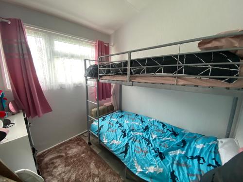 a bedroom with two bunk beds and a window at 348 Golden Sands in Withernsea