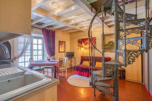 a kitchen and a living room with a spiral staircase at La Chapelle du Miracle in Avignon