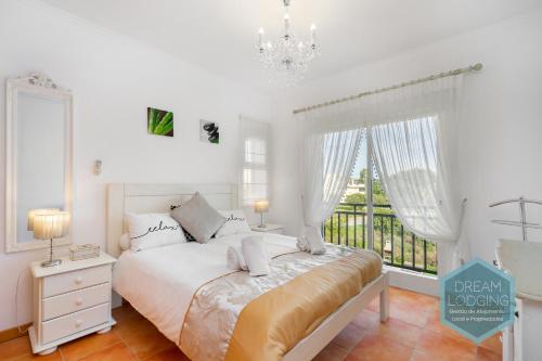 biała sypialnia z łóżkiem i oknem w obiekcie Quinta do Paiva 10A Dream Lodging w Albufeirze