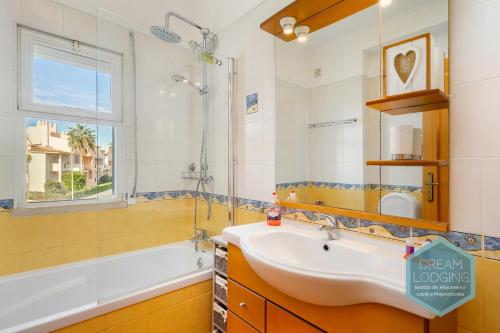 W łazience znajduje się umywalka, wanna i lustro. w obiekcie Quinta do Paiva 10A Dream Lodging w Albufeirze