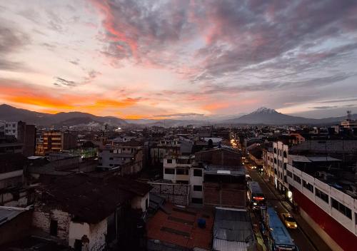 a view of a city at sunset with a mountain at La Merced Plaza Hospedaje in Riobamba