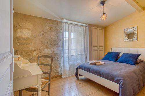 a bedroom with a bed and a desk and a window at La Chapelle du Miracle in Avignon