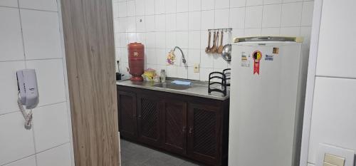 a kitchen with a sink and a refrigerator at Apartamento PRAIA in Cabo Frio