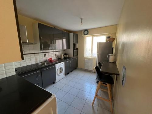 een keuken met een koelkast en een vaatwasser bij Magnifique appartement de 90m2 dans une zone pavillonnaire d'Evry in Courcouronnes