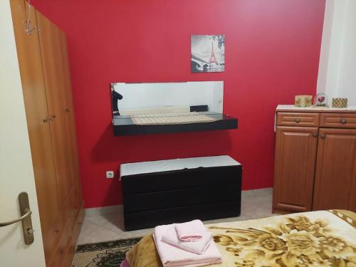 a room with a bed and a red wall at Apartment in quiet neighbourhood in Alimos in Athens
