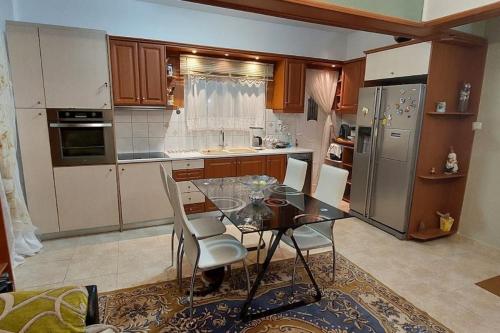 Apartment in quiet neighbourhood in Alimos في أثينا: مطبخ مع طاولة زجاجية وكراسي فيه
