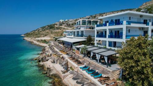 a hotel on a hill next to the ocean at Fabeno Villa in Sarandë