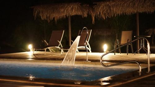 a swimming pool with chairs and a water fountain at Complejo Enrique Joaquin in Mercedes