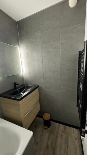 a bathroom with a sink and a bath tub at Studio la Mongie Tourmalet 2 étoiles in Bagnères-de-Bigorre