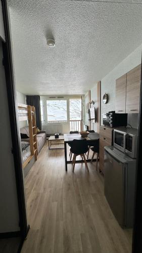 un salon avec une table et une cuisine dans l'établissement Studio la Mongie Tourmalet 2 étoiles 4 couchages, à La Mongie