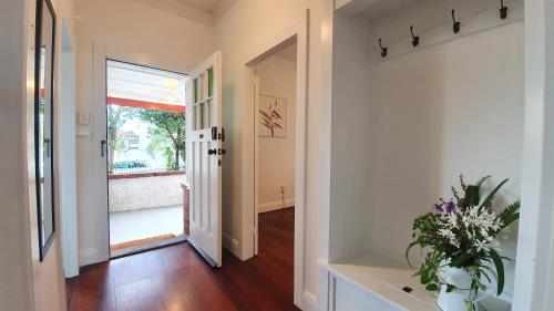 un pasillo con una puerta y un jarrón de flores en Kingsland Family Home, en Auckland