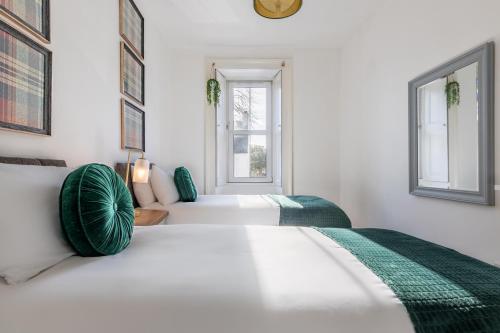 Thistle do Nessly في إينفيرنيس: سريرين في غرفة بيضاء مع وسائد خضراء