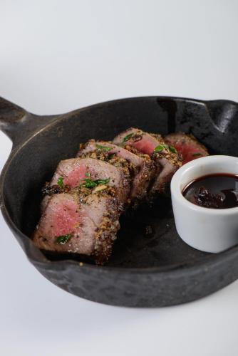 a pan with meat and a bowl of sauce at Cabin Resort in Moshav Ramot