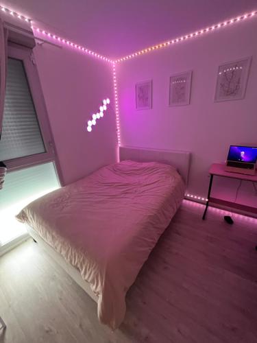 ein Schlafzimmer mit einem Bett mit Beleuchtung in der Unterkunft Chambre à louer avec salle de bain privative in Carrières-sous-Poissy