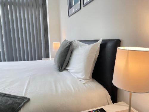 a bedroom with a bed with pillows and a lamp at 4 Bedroom 2 Bathroom Shared House - Near BHX and NEC in Birmingham