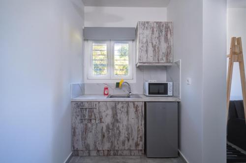 a small kitchen with a sink and a microwave at Molos Beachfront Apartments in Diakopto in Diakopto