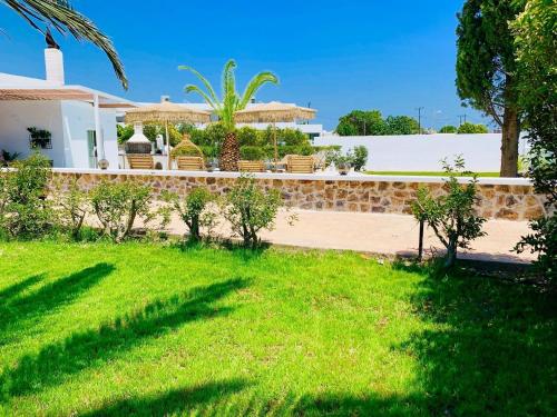 a backyard of a house with a green lawn at Ferienhaus mit Privatpool für 6 Personen ca 105 m in Faliraki, Ägäis Rhodos in Faliraki