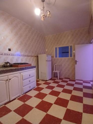 een keuken met een rode en witte geruite vloer bij Dar zahra in Aourir