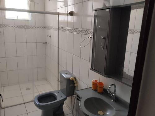 a bathroom with a toilet and a sink and a mirror at Andre's Home casa M in Governador Valadares