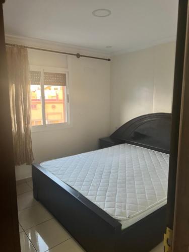 a bedroom with a bed in a room with a window at Nador El jadid in Nador