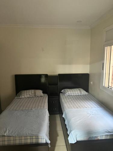 two beds sitting next to each other in a bedroom at Nador El jadid in Nador