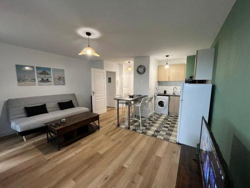 un salon avec un canapé et une table dans l'établissement Appartement avec jardin à Rochefort, à Rochefort