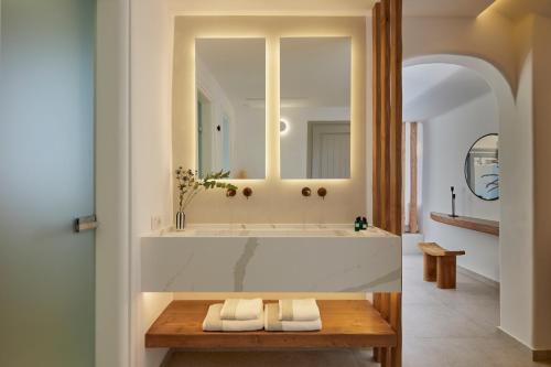 a bathroom with a tub with two towels on a table at Phos The Boutique in Akrotiri