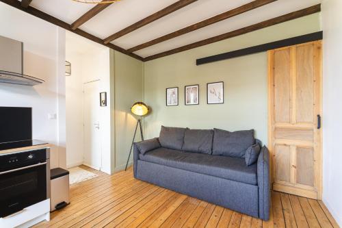 salon z kanapą i telewizorem w obiekcie LE LUXUEUX - Netflix I WIFI I CENTRE - Design & Cosy w mieście Valenciennes