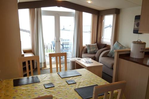 una cucina e un soggiorno con tavolo e divano di Cozy and relaxing with stunning sea views a Lytchett Minster