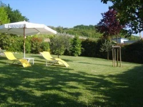eine Gruppe gelber Stühle und ein Regenschirm in einem Hof in der Unterkunft Ferienwohnung für 4 Personen ca 65 m in San Miniato, Toskana Provinz Florenz in San Miniato