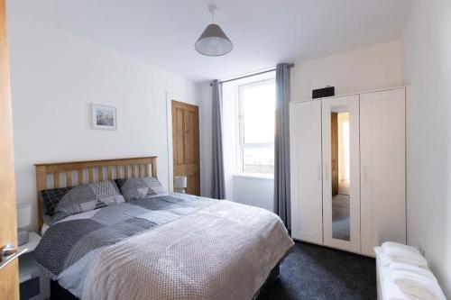 a bedroom with a bed and a large window at Helensburgh Holiday Apartment in Helensburgh