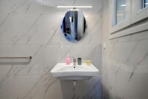 a white bathroom with a sink and a mirror at Molos Beachfront Apartments in Diakopto in Diakopto