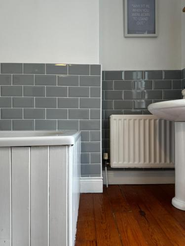 a room with gray subway tiles and a radiator at The Victorian Townhouse Portrush in Portrush